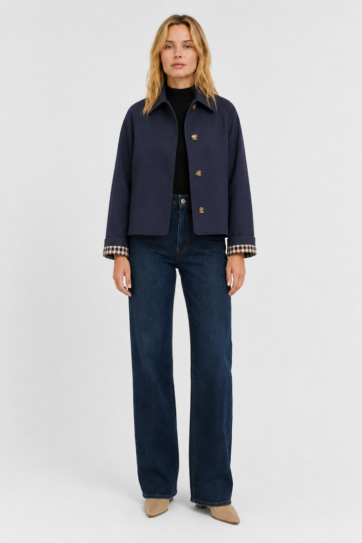Women's navy blue lightweight jacket, front view buttoned over a black top with dark wide-leg jeans.