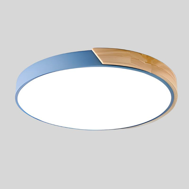 Blue round ceiling light with a natural wood segment on the rim and bright white diffuser, product shot on a gray background.