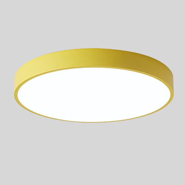 Yellow round slim ceiling light with a plain rim and glowing white diffuser, shown alone against a gray background.