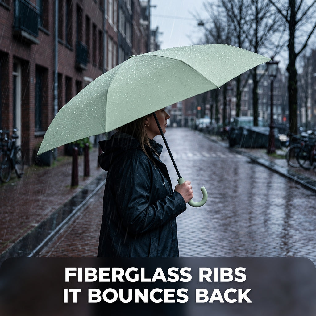 Woman holding the open green umbrella on a rainy street.