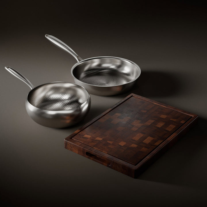 Hammered titanium frying pan and sauté pan set with a walnut cutting board and utensils