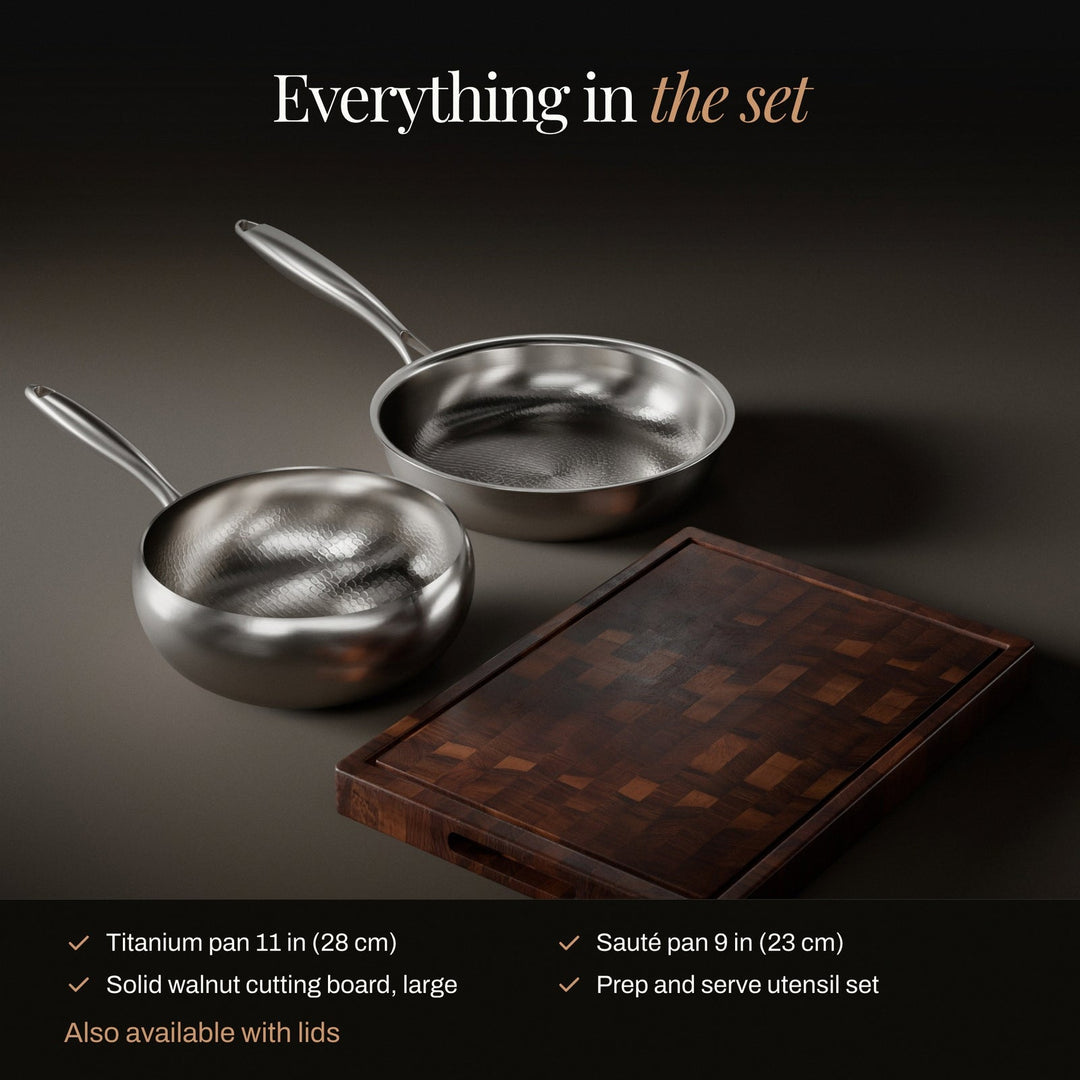 Hammered titanium frying pan and sauté pan set with a walnut cutting board and utensils, another view