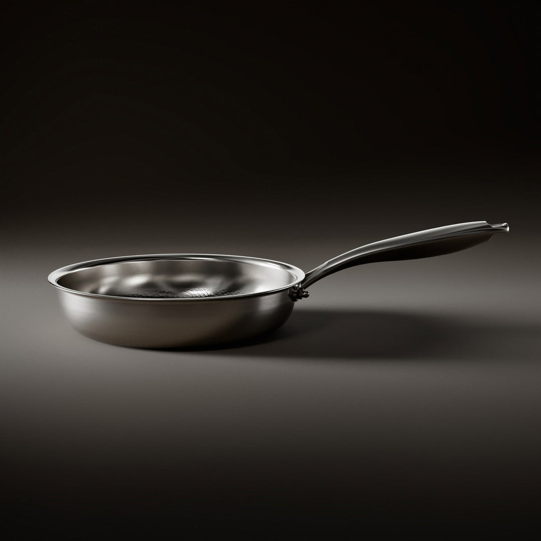 Silver hammered titanium frying pan, another view, showing the low sidewall and curved steel handle.