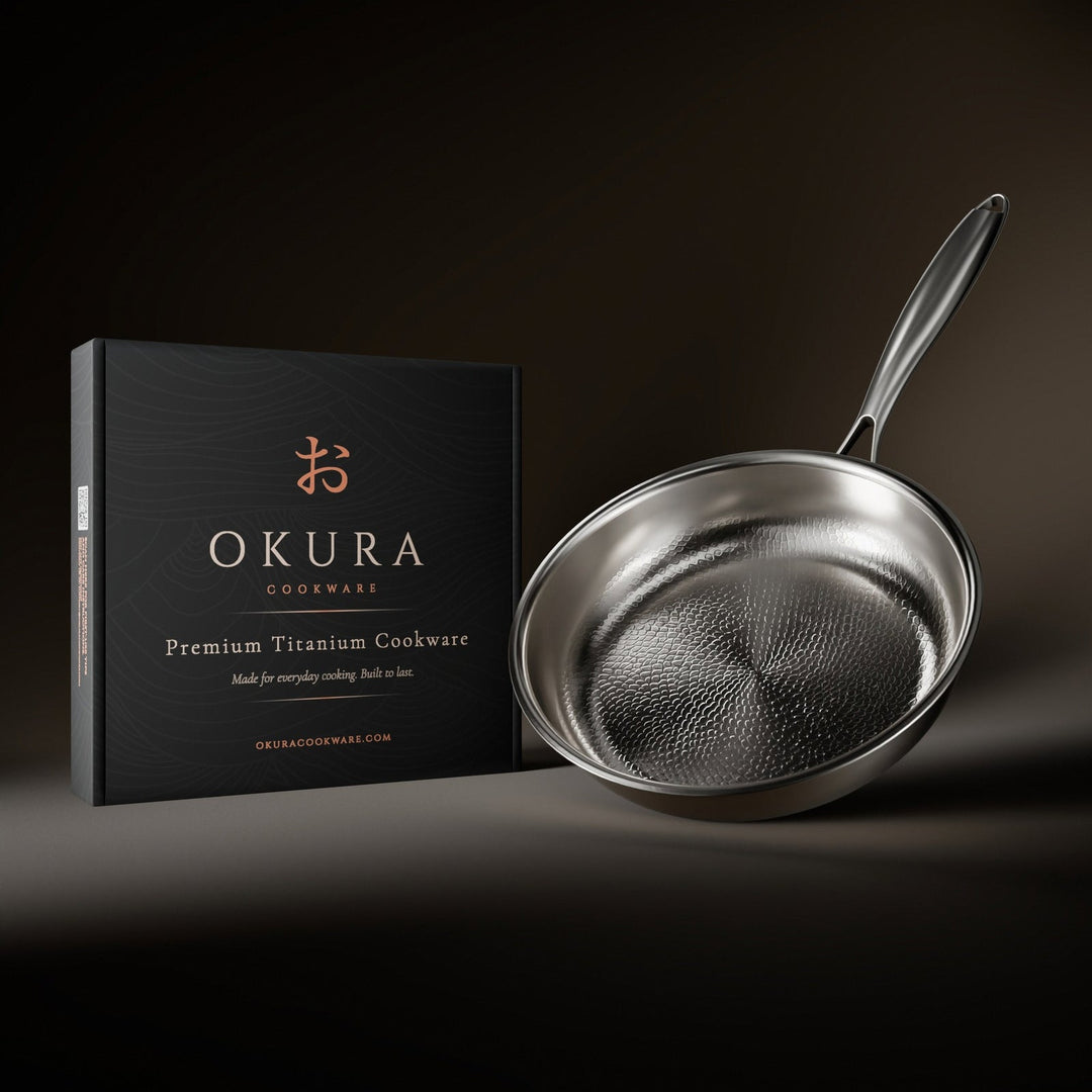 Silver hammered titanium frying pan beside its black presentation box.