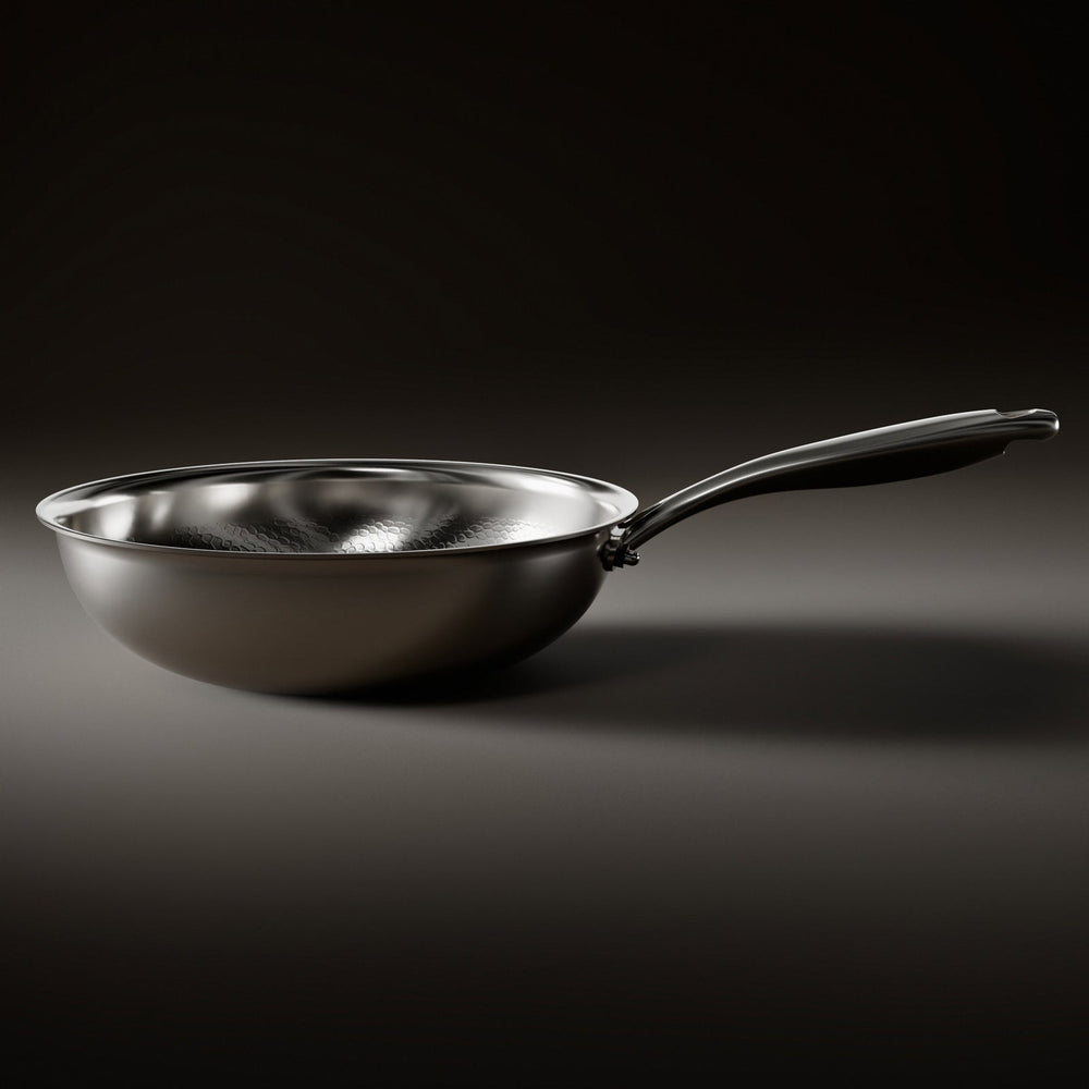 Side view of the wok pan on a dark surface, showing its rounded bowl, flat base and long steel handle. 2