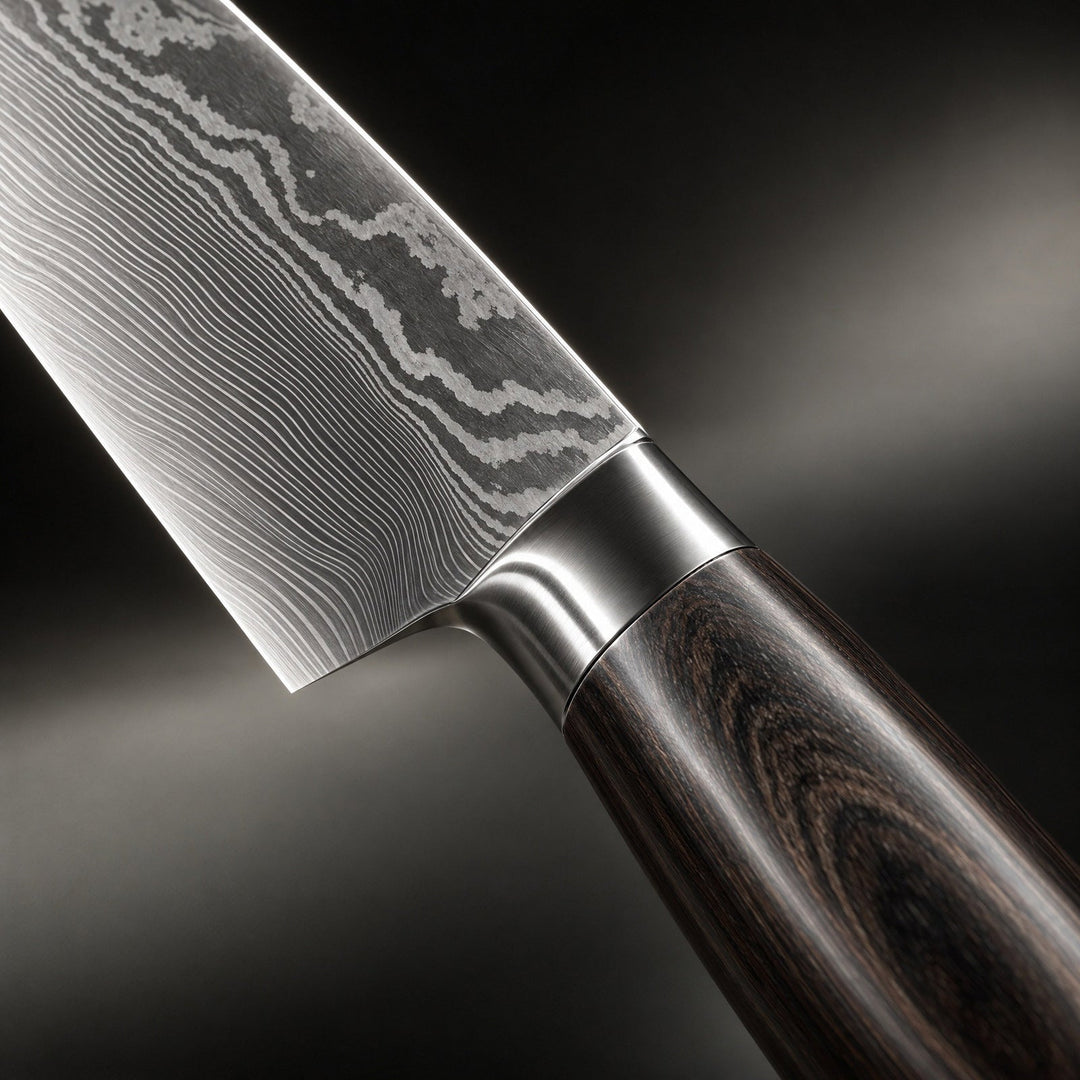Detail of the blade-to-handle joint showing the wavy layered steel pattern and the dark wood grain handle.