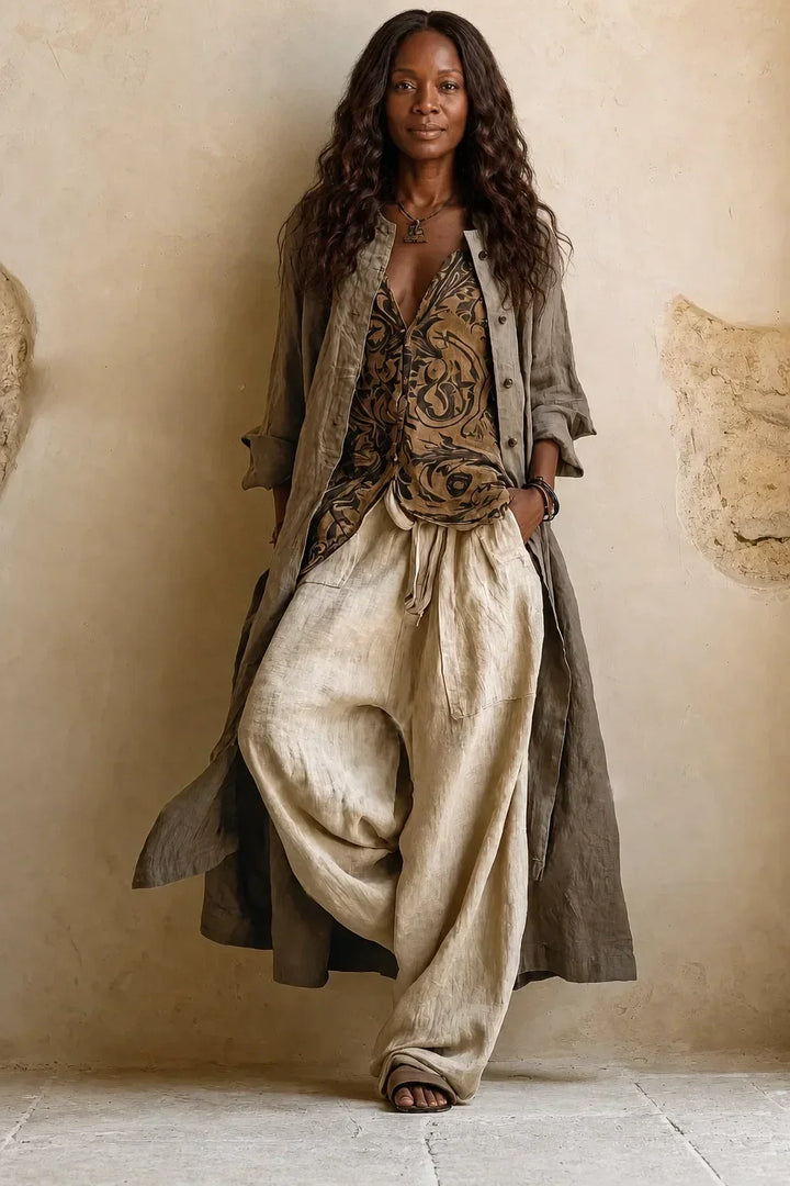 Front view of the model in the complete outfit, long gray-green cardigan layered over the printed top and loose beige pants 3