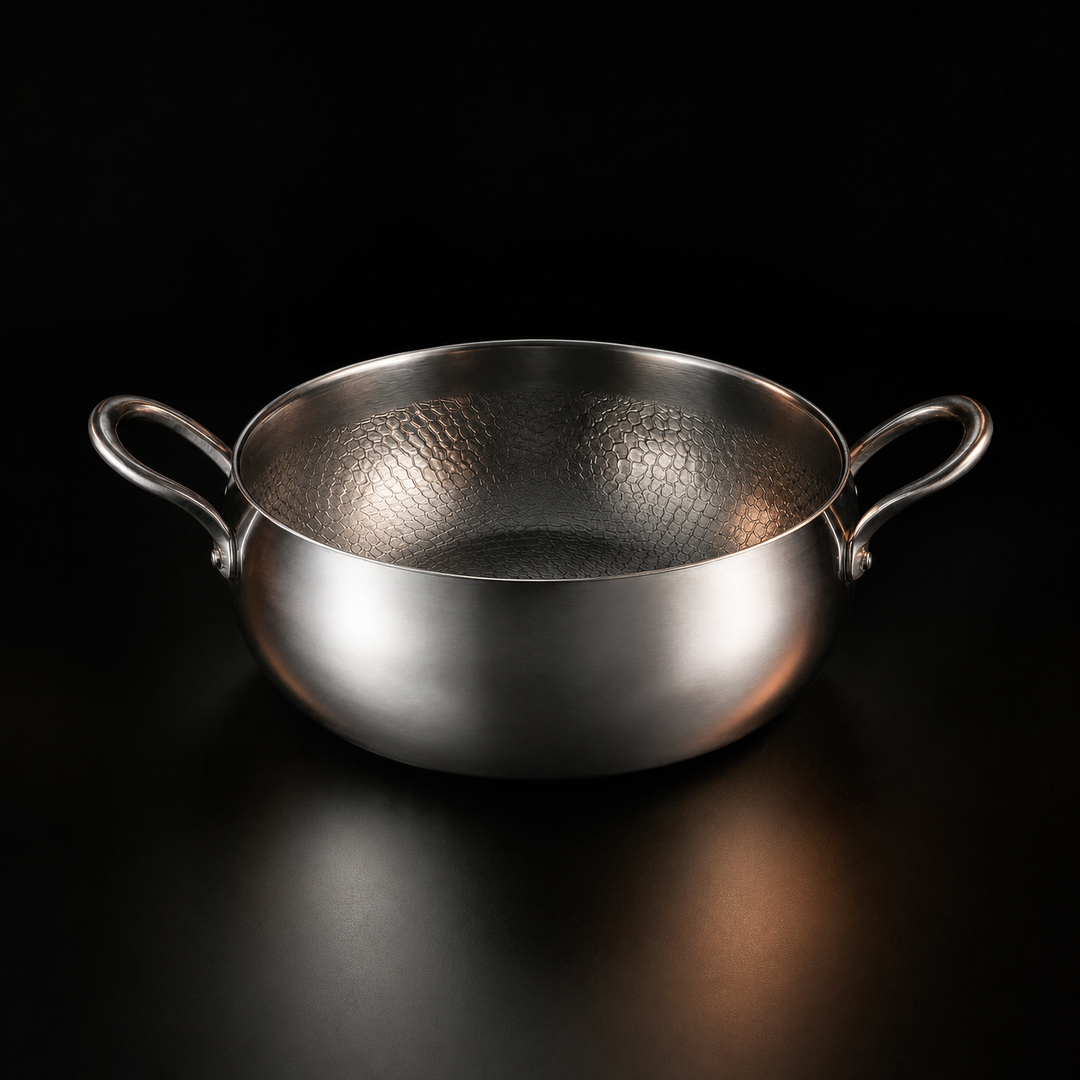 Silver metal stockpot with two loop handles and a hammered interior, uncovered, front view.