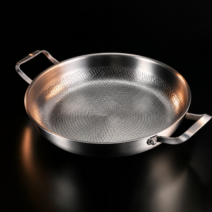 Empty pan seen from the side at an angle against a black background, showing the scale-like hammered texture inside and the two side handles. 1