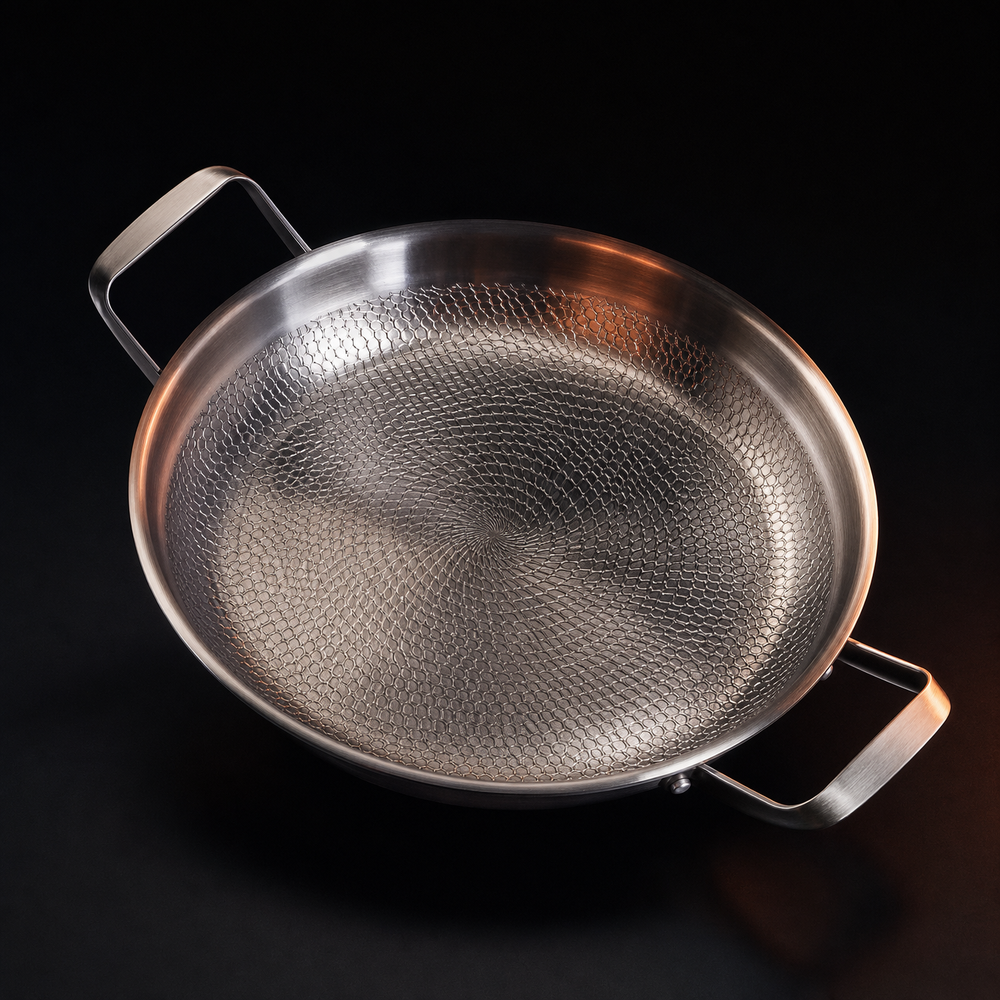 Top-down view of the empty pan on a dark background, showing the honeycomb hammered pattern spiraling across the cooking surface and both handles. 2