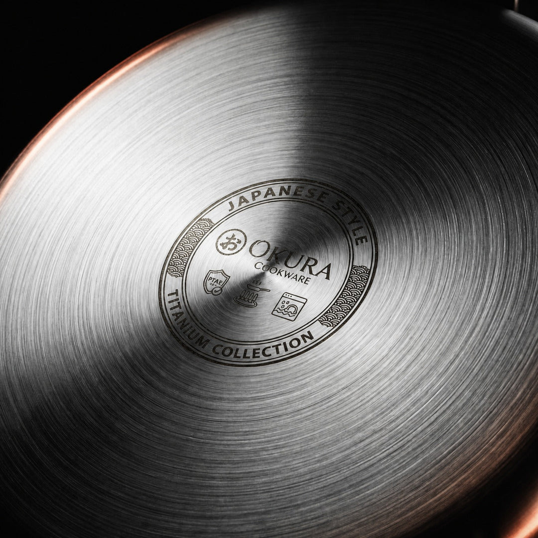 Detail of the underside of a frying pan with a brushed concentric finish and engraved emblem.