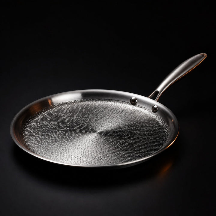 Hand-Hammered Titanium Crepe Pan, PFAS-Free in silver with a textured surface and brushed metal handle.