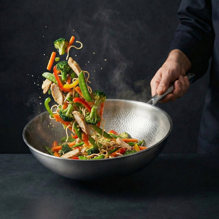 Hammered titanium wok pan with noodles and vegetables being tossed, another view.