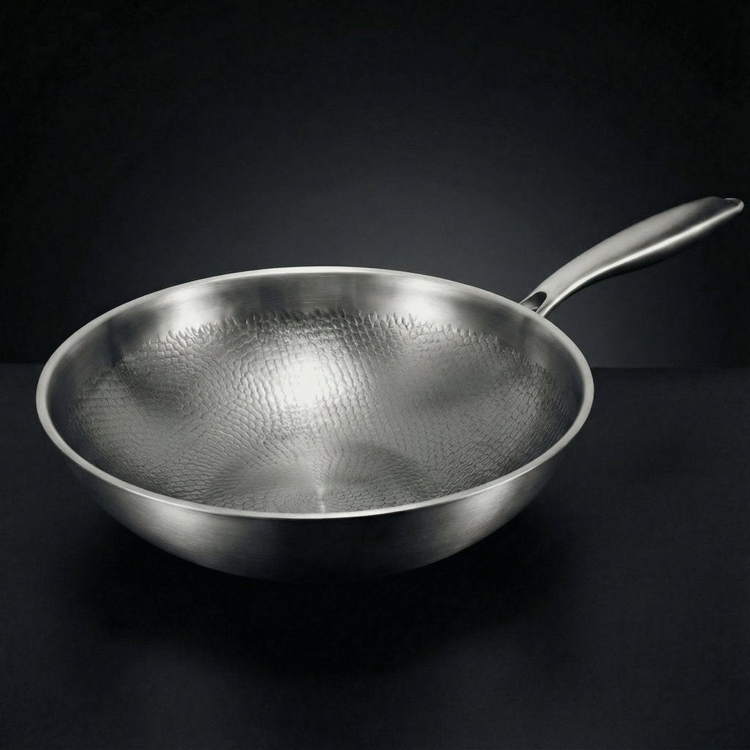 Detail of the wok-style pan with a long handle and hammered-pattern interior.