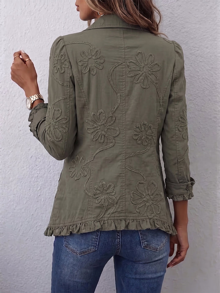 Back view of the olive green jacket on a model, showing the embossed floral pattern, ruffled hem and cuffed sleeves. 2