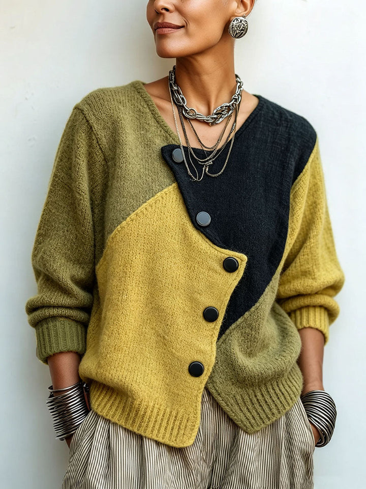 Close front view of the color-block knit sweater with diagonal black buttons, styled with layered silver necklaces and 1