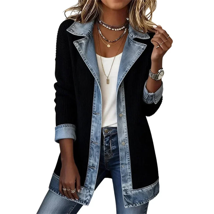 Front view on a model of the black ribbed coat with denim lapels, placket, cuffs and hem over a white top. 13