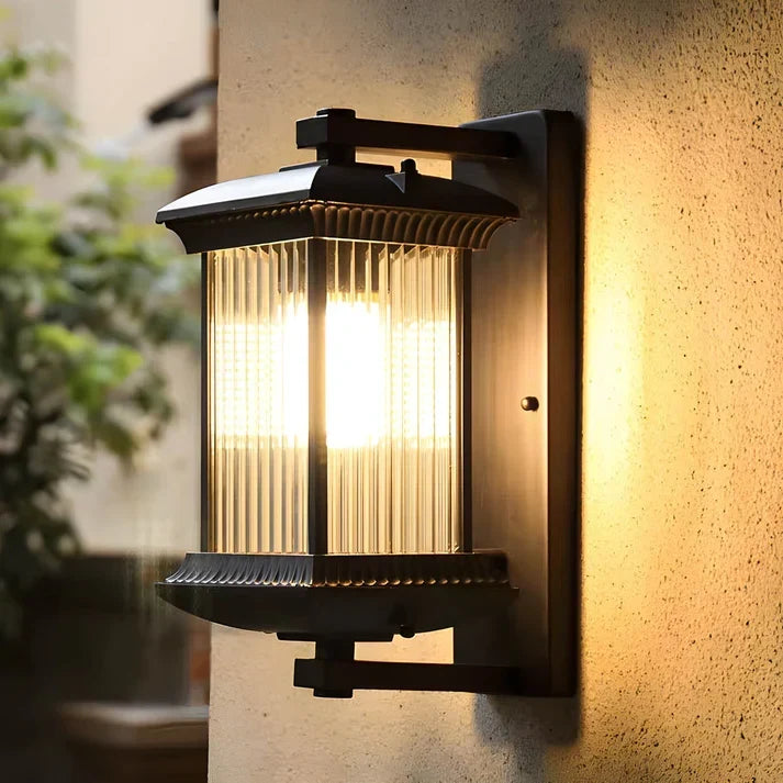 Angled close-up of the glowing fluted glass lantern and its black bracket against a textured stucco wall. 4