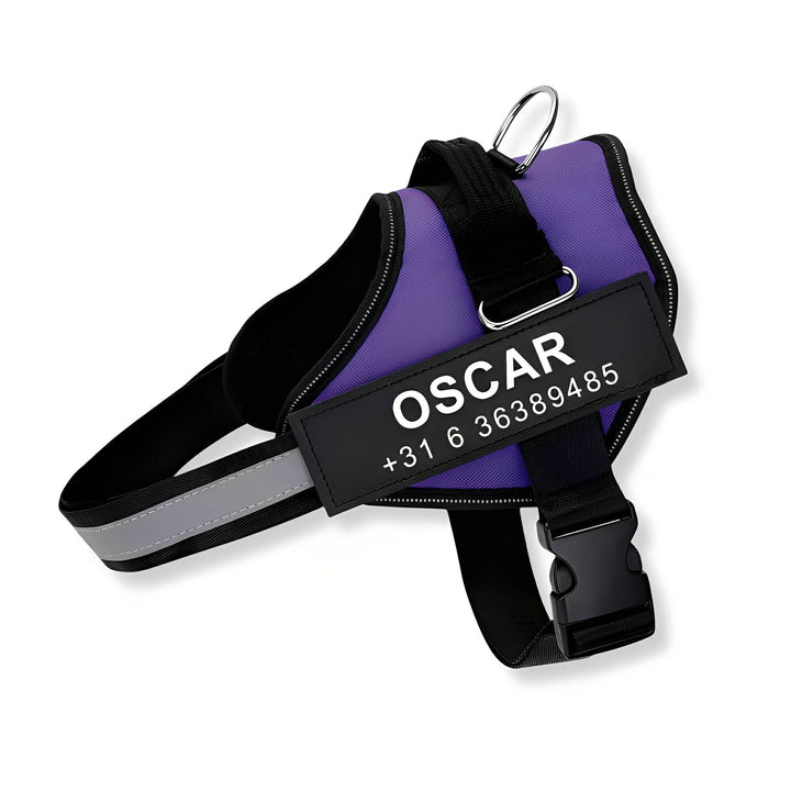 Purple harness on a white background with a black personalized name and number patch, reflective strap, metal leash ring and side-release buckle.