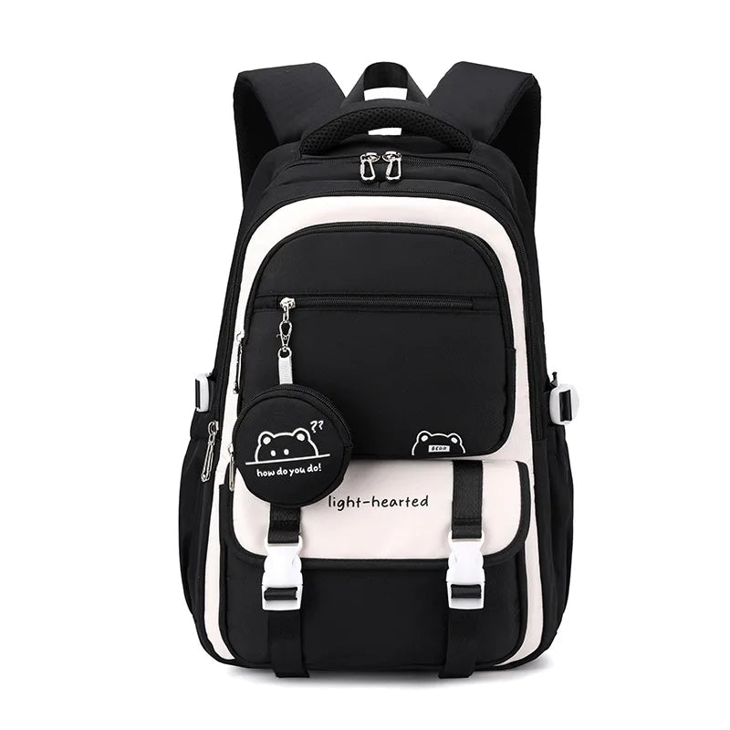 Front view of the same backpack in black and cream, with the black bear charm pouch and white buckles on the flap. 11