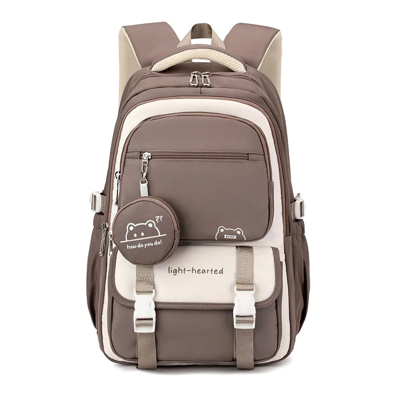 Front view of the same backpack in brown and cream, with the round bear charm pouch and white buckles. 8