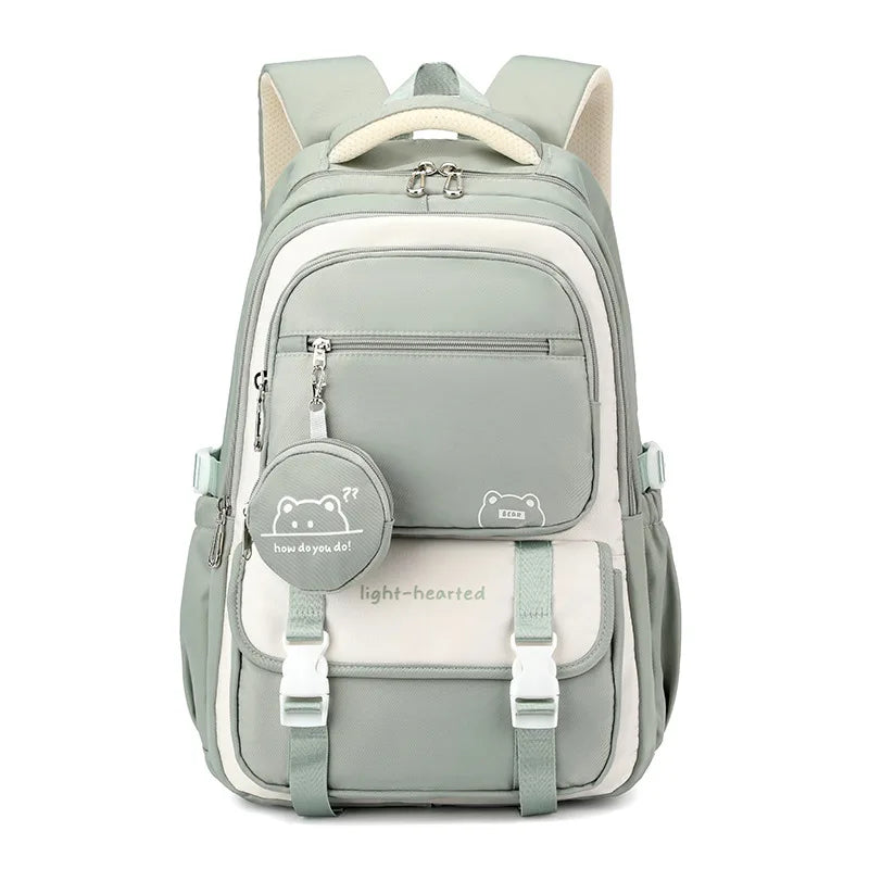 Front view of the same backpack in sage green and cream, with the round bear charm pouch and buckled flap. 9