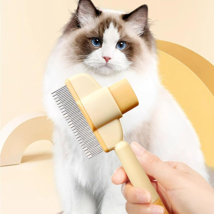Cream and yellow grooming comb brushing a fluffy white and brown cat.