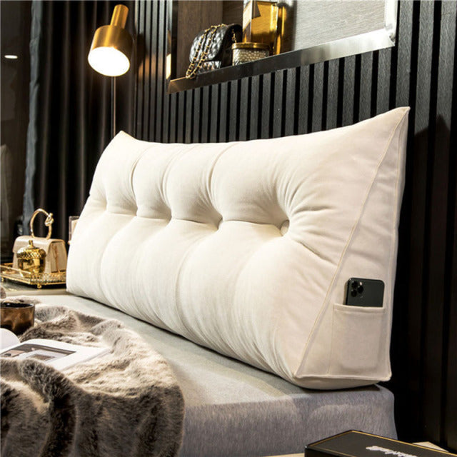another view of a cream white tufted velvet wedge pillow with a phone in the side pocket.