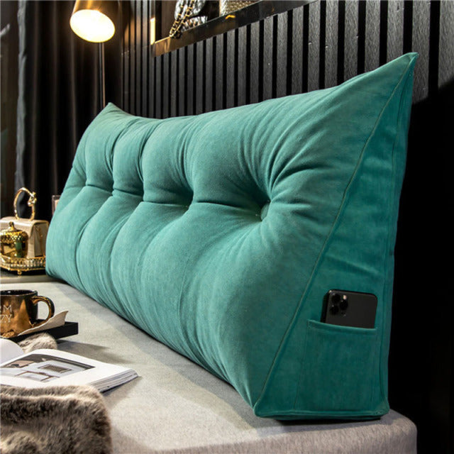 another view of a teal green tufted wedge pillow with a phone in the side pocket.