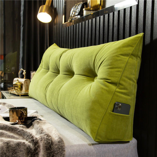 another view of a lime green tufted velvet wedge pillow with a gold mug nearby.