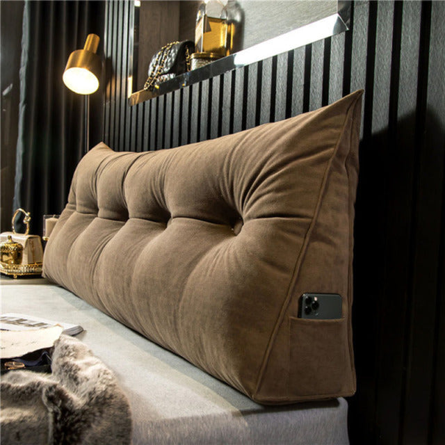 another view of a brown tufted velvet wedge pillow with a phone in the side pocket.