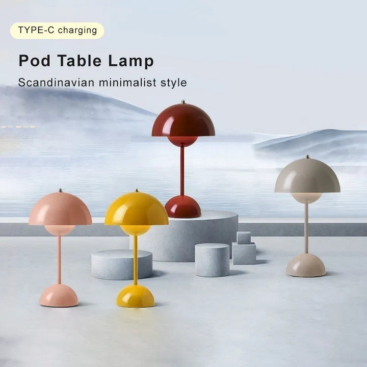 Another view of four dome lamps in coral pink, yellow, deep red and gray on pale stone blocks.