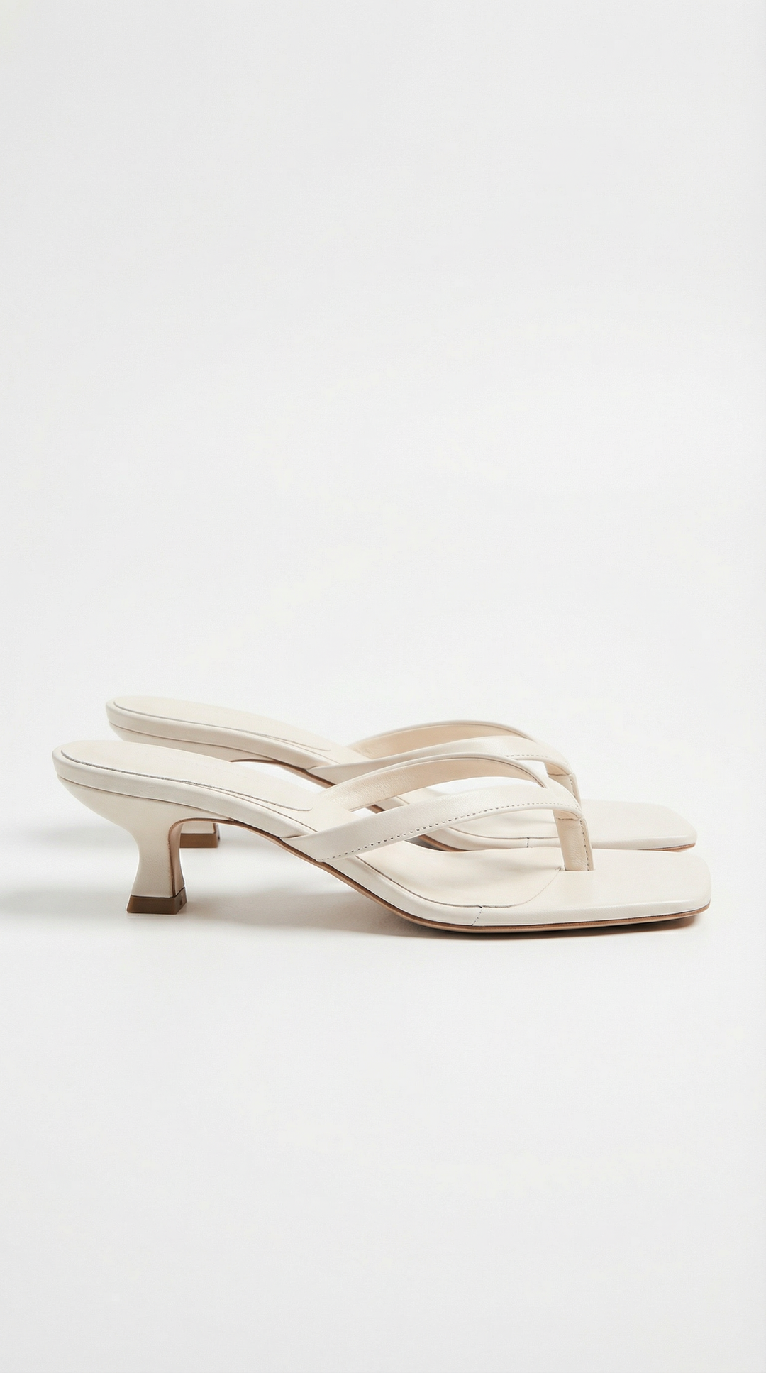 Pair of cream off-white square-toe thong sandals with a low kitten heel