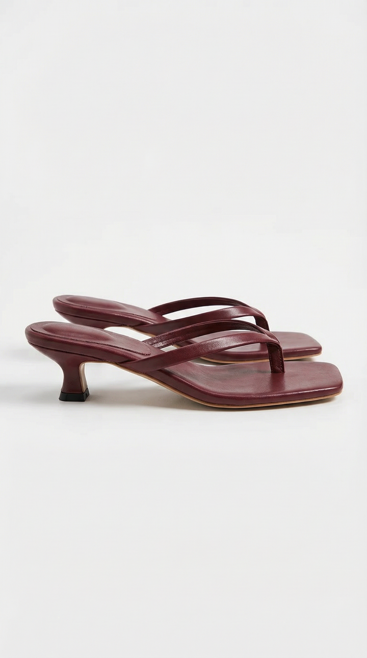 Pair of burgundy square-toe thong sandals with a low kitten heel and a black heel tip