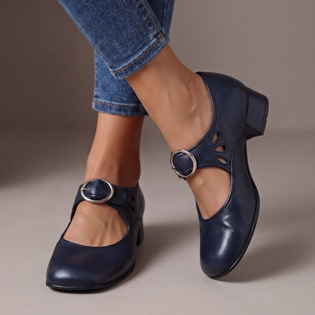 Blue leather block-heel pumps with a round silver buckle strap and teardrop cutouts, another view.