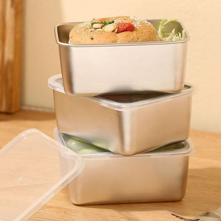 Three containers stacked on a wooden surface, with a pastry on top and a clear lid leaning beside 10