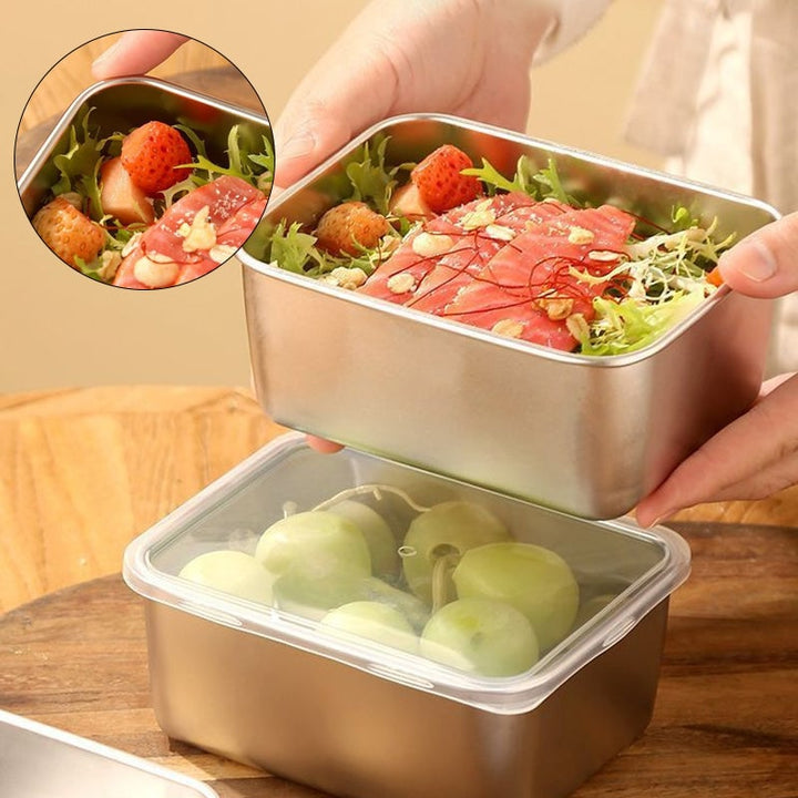 Hands lift a steel container of salad with salmon above a lidded container holding green grapes 1