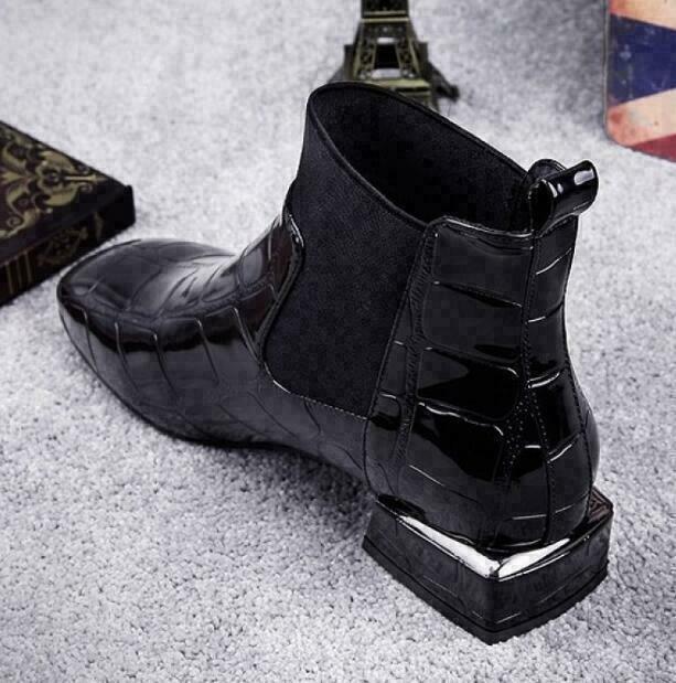Rear three-quarter view of the black boot highlighting the pull tab and chunky block heel with metallic trim 3