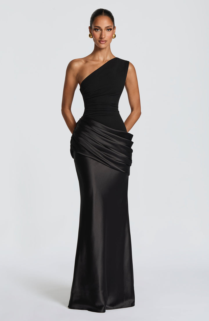 Front view of the burgundy maxi dress with hands tucked in pockets, showing the draped satin hip and floor-length skirt. 39