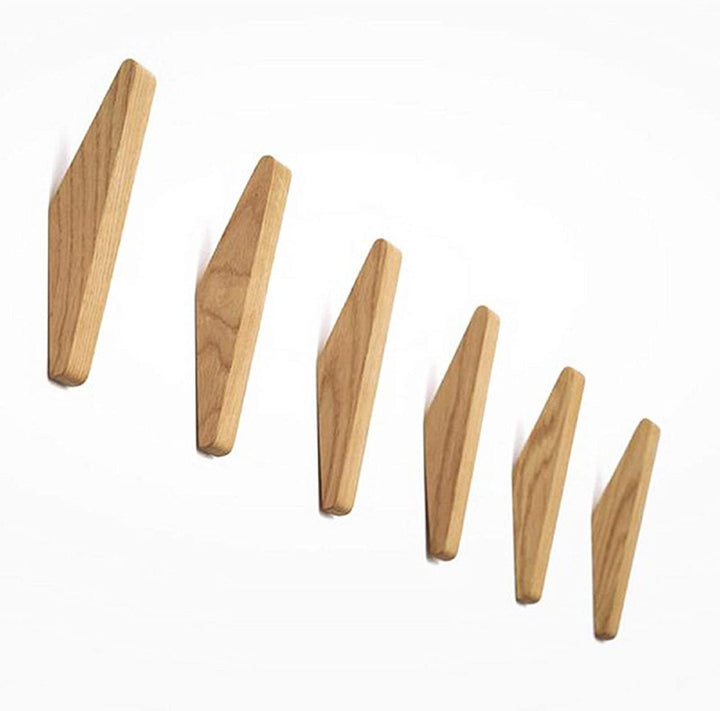 Six light wooden hooks of graduated sizes arranged in a diagonal line, showing the grain and angular shape on a white background. 5
