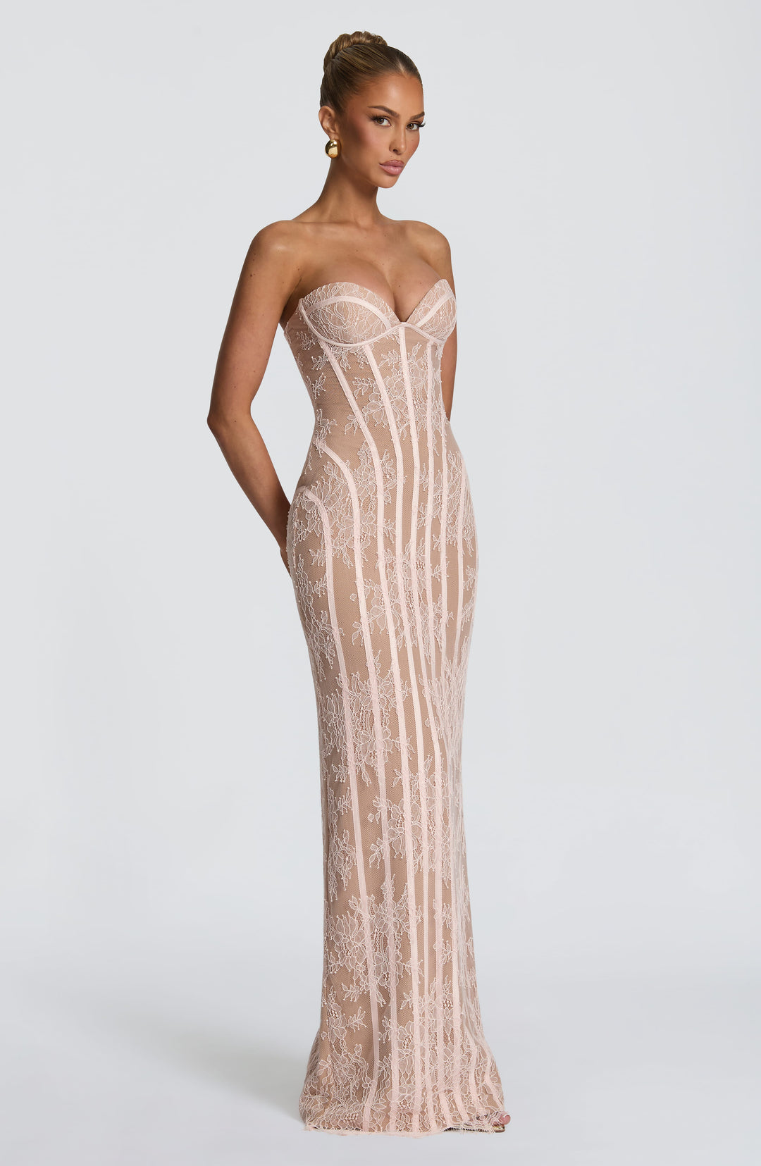Three-quarter view of the blush pink strapless lace maxi dress, showing the fitted corset bodice and column skirt.