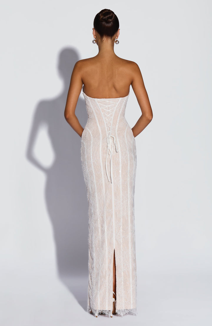 Back view of the white beaded lace dress showing the lace-up corset back, long ties and a center back slit.