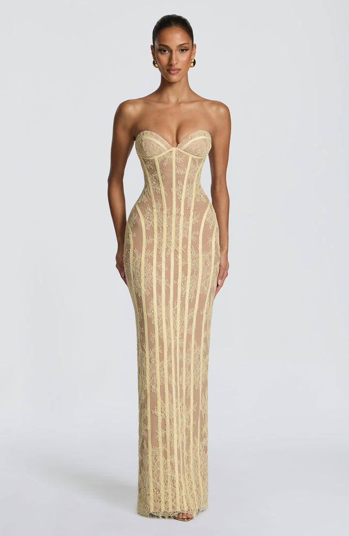 Full-length front view of a model wearing the pale yellow strapless lace maxi dress with sweetheart bustline, vertical boning and floral lace over a nude lining 21