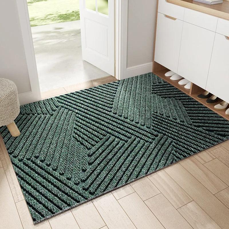 Green geometric plastic doormat by an entryway with a shoe cabinet and wood floor.