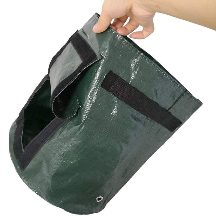 Another view of an empty green grow bag with a black carry strap and open flap.