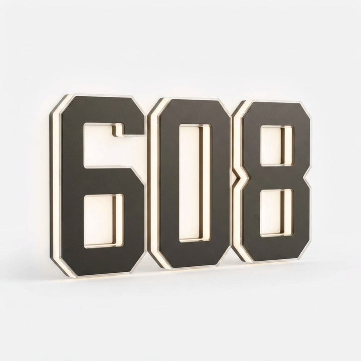Angled studio view of three dark numerals with a soft glowing edge on a white background 19
