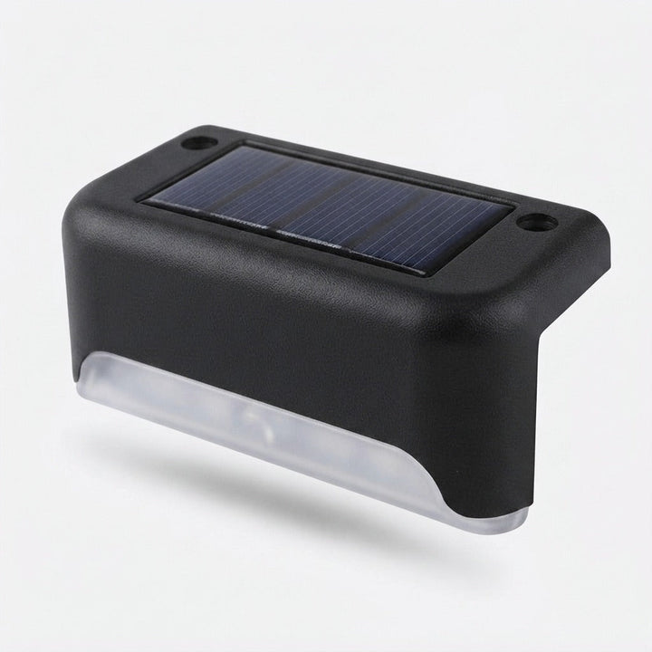 Single black solar step light detail on a plain light background, showing the solar panel on top and clear light strip below.