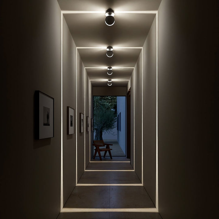 White LED wall sconce another view showing glowing rectangular light frames in a dark hallway.