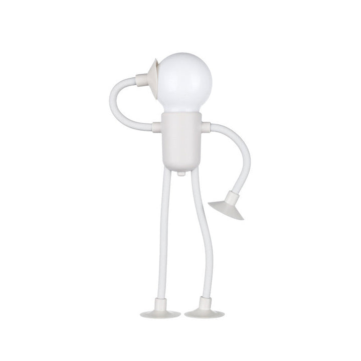White figure lamp with a glowing bulb head and flexible arms on suction-cup feet.