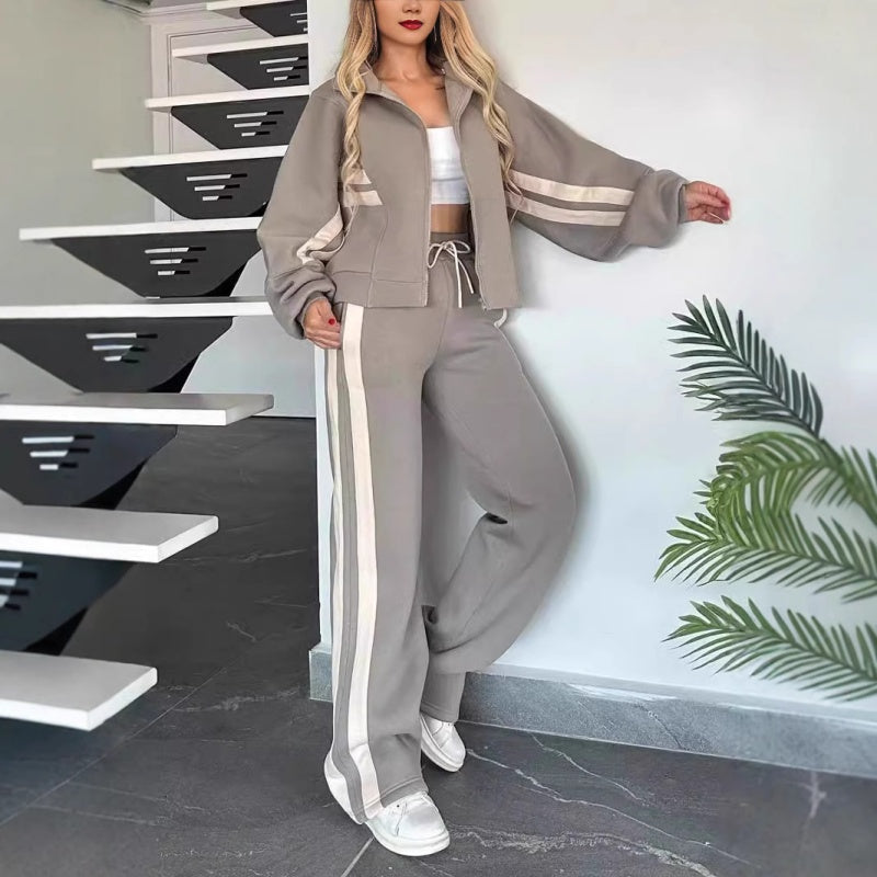 Beige lounge set another view with contrast stripes, jacket zipped over a white crop top.